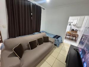 a living room with a couch with three pillows at Casa 2 dorms com garagem e Wi-Fi in São Paulo