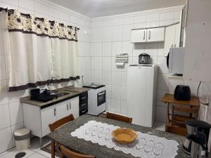 a kitchen with a table with chairs and a table and a kitchen with a table at Casa 2 dorms com garagem e Wi-Fi in São Paulo +39 photos