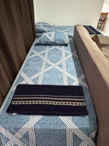 two beds in a room with a couch at Casa 2 dorms com garagem e Wi-Fi in São Paulo