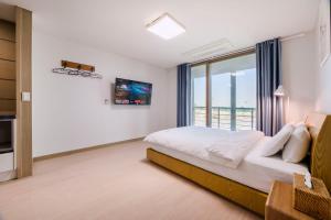 a bedroom with a bed and a large window at Dorami Pension in Seogwipo +38 photos