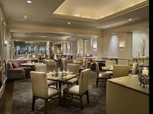 a restaurant with tables and chairs and a bar at Fairmont Dallas in Dallas