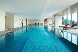 a large swimming pool with a person standing in the background at Shunde Marriott Hotel in Shunde