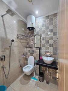 a bathroom with a toilet and a sink at Aarunya Stays in Rishīkesh