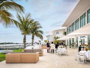 people standing outside of a building with palm trees at Hamilton Princess & Beach Club A Fairmont Managed Hotel in Hamilton