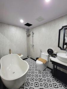 a bathroom with a tub and a toilet and a sink at Anara Sapa Hotel in Sapa +32 photos