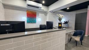a reception desk with chairs and a vase of flowers at The Metropolitan Spring Hill in Brisbane