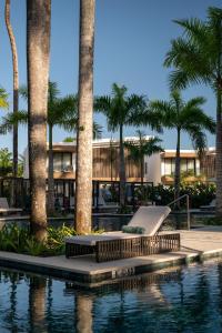 a resort with palm trees and a swimming pool at Donoma Las Terrenas Resort & Villas, Autograph Collection in Las Terrenas