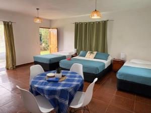 a bedroom with two beds and a table and chairs at Cabañas Honu Nui Inn in Hanga Roa +50 photos