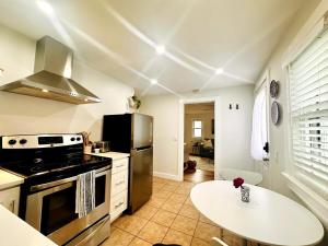 a kitchen with a stove and a table in it at Shorebreak Cottage in North Kingstown