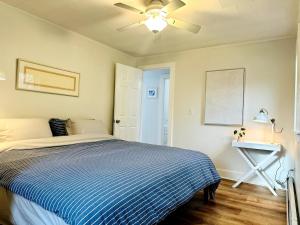 a bedroom with a bed and a ceiling fan at Shorebreak Cottage in North Kingstown