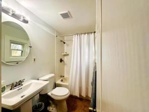 a white bathroom with a sink and a toilet at Shorebreak Cottage in North Kingstown +13 photos