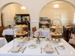 a table with cakes and pastries on top at Honeysuckle Inn - Violet Town in Violet Town