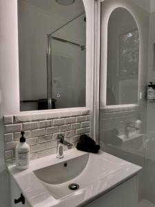 a white bathroom with a sink and a mirror at Honeysuckle Inn - Violet Town in Violet Town +21 photos