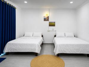 two beds in a room with a rug and a table at David's Hostel & Restaurant in Kaôh Rŭng (3) +37 photos
