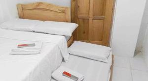 two beds with white sheets and a wooden door at RF Hotel Transient House in Bangued