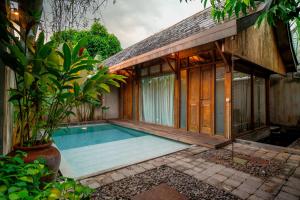 ein Swimmingpool vor einem Haus in der Unterkunft Ayom Java Village Solo in Solo