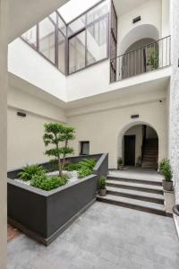 a building with a staircase and a tree in a courtyard at Altrove Boutique Studios in Caserta