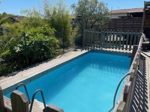 a large blue swimming pool with two chairs next to it at Le gîte sabotier in Nerbis