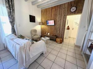 a bedroom with a bed and a chair and a clock at Le gîte sabotier in Nerbis
