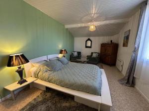 a bedroom with a bed and two lamps and a couch at Le gîte sabotier in Nerbis +22 photos
