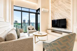 a living room with a couch and a tv at Societe Hartamas in Kuala Lumpur