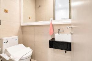 a bathroom with a toilet and a sink and a mirror at Societe Hartamas in Kuala Lumpur