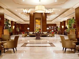 a lobby of a hotel with chairs and a table at Raffles Makkah Palace in Mecca