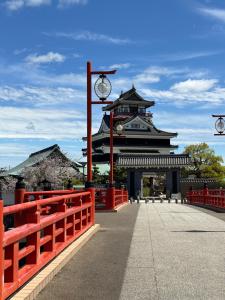 a building with a red fence and a street light at Nagoya kiyosu温もりの宿貸切一軒家駅近3分 in Nishi-biwajima
