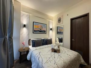 a bedroom with a large bed and a table at Ocean Garden Villas 7th Floor - Road Side in Boracay