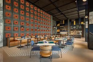 a restaurant with tables and chairs in a room at Aloft by Marriott Xiamen Xiangan in Xiamen