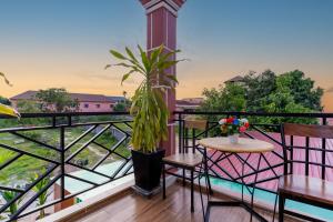 a balcony with tables and chairs and a view at 855 Villa Siem Reap in Siem Reap