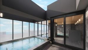a swimming pool in a building with glass windows at Village Atami in Atami