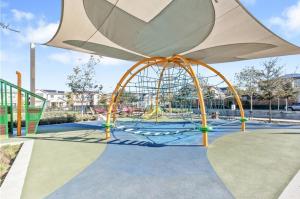 a playground with a swing set in a park at Bright and Cozy Bay Window Cottage 6 in Ontario