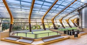 a tennis court in a large room with windows at Wan Wan Paradise Izukogen in Ito
