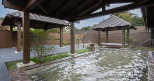 a swimming pool in a backyard with a pergola at Wan Wan Paradise Izukogen in Ito