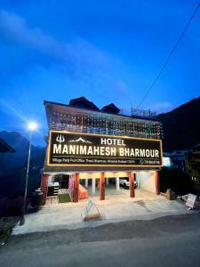 a hotel with a sign on the side of it at Hotel Manimahesh Bharmour in Brāhmaur