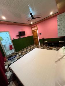 a room with a white table and a pink wall at Hotel Manimahesh Bharmour in Brāhmaur +34 photos