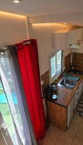 a kitchen with a red curtain next to a sink at Studio à deux pas de Monaco in Roquebrune-Cap-Martin