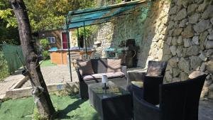 a patio with a chair and a table and a stone wall at Studio à deux pas de Monaco in Roquebrune-Cap-Martin