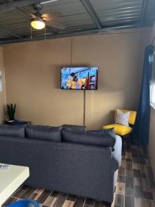 a living room with a couch and a tv on the wall at Cozy Comfy Budget Friendly in San Fernando