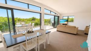 a living room with a dining table and a couch at Beachside Beauty in Caves Beach
