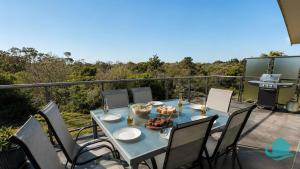 a blue table with chairs on a balcony at Beachside Beauty in Caves Beach
