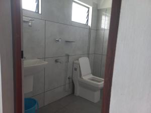 a bathroom with a toilet and a sink and a window at Serene Enclave in Nedumbassery