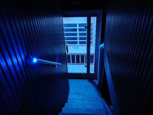 a door with a blue light in a dark room at Romantic Ocean View Studio at Stanwell Tops in Stanwell Park