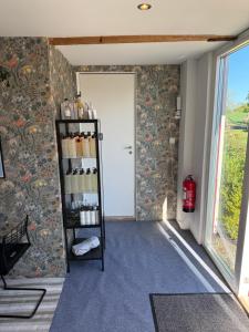 ein Zimmer mit einer Tür und einem Regal mit Flaschen in der Unterkunft Peppinge Bed & Breakfast in Löderup