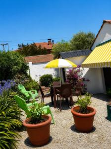 a patio with a table and chairs and an umbrella at Apart Los Cerrillos in Balcarce