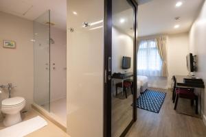 a bathroom with a shower and a toilet and a desk at 24 Inn at BTS Phrom Phong in Bangkok +43 photos