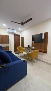 a living room with a blue couch and chairs at Hotel Mount Royale in Hyderabad