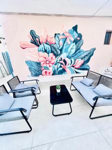 a room with chairs and a flower mural on the wall at ΑVLI Sarti Studios & Apartments no1 in Sarti