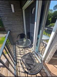 a patio with a table and chairs on a porch at Le Petit L Orée des Bois in Blainville-sur-lʼEau